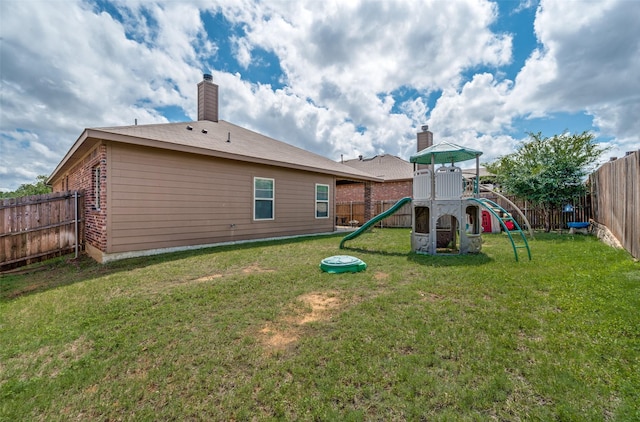 5825 Loveland Dr, Denton, TX 76208 - back of house with a playground, a chimney, and brick siding
