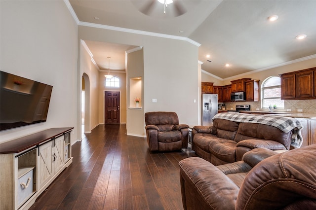 5825 Loveland Dr, Denton, TX 76208 - living area featuring arched walkways, ceiling fan, dark wood finished floors, ornamental molding, and vaulted ceiling