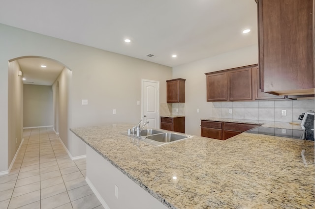 2113 Rubin Rd, Fate, TX 75189 - kitchen featuring arched walkways, a sink, light tile patterned floors, decorative backsplash, and recessed lighting