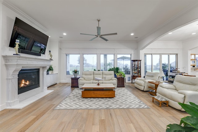 2012 Spieth St, Granbury, TX 76048 - living room featuring arched walkways, light wood-style flooring, a ceiling fan, recessed lighting, and a premium fireplace