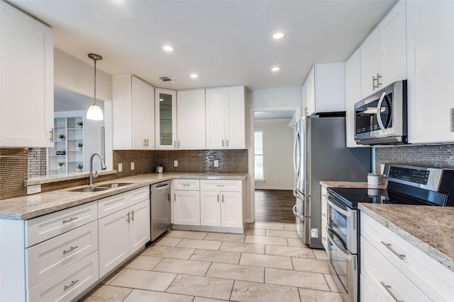 2309 Merrimac Dr, Plano, TX 75075 - kitchen with appliances with stainless steel finishes, a sink, tasteful backsplash, white cabinets, and recessed lighting