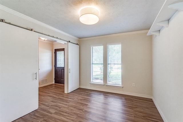 2309 Merrimac Dr, Plano, TX 75075 - unfurnished room featuring a barn door, wood finished floors, crown molding, baseboards, and a textured ceiling