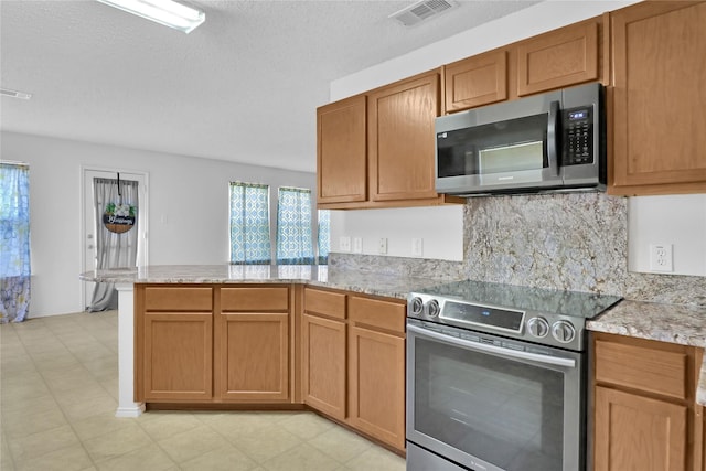 8300 Southern Prairie Dr, Fort Worth, TX 76123 - kitchen with stainless steel appliances, a peninsula, tasteful backsplash, light stone countertops, and light floors
