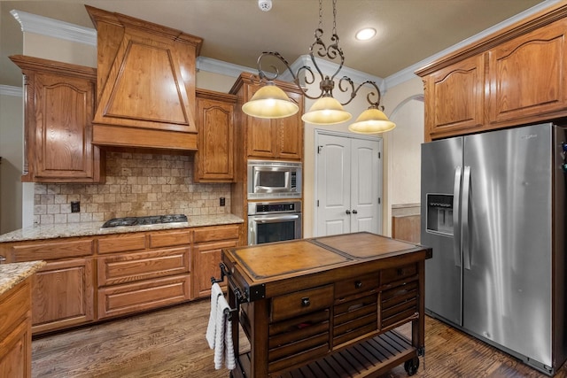 1205 Platte Dr, Mansfield, TX 76063 - kitchen featuring stainless steel appliances, crown molding, custom range hood, backsplash, and brown cabinetry