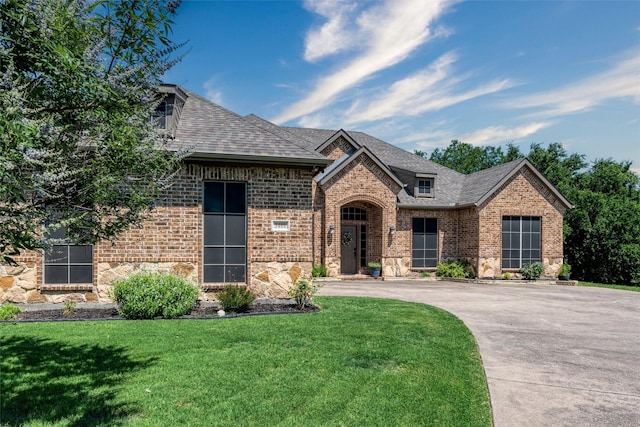 3400 Eisenhower Ave, Melissa, TX 75454 - french country home with brick siding, a front yard, stone siding, driveway, and roof with shingles