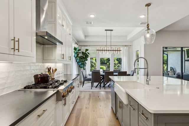 32 Katie Ln, Trophy Club, TX 76262 - kitchen with a sink, stainless steel appliances, wall chimney exhaust hood, a tray ceiling, and decorative backsplash