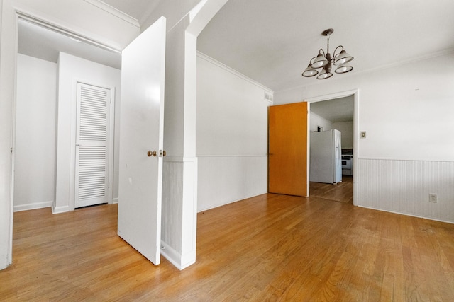 6908 Park Place Dr, Richland Hills, TX 76118 - empty room with wood finished floors, a chandelier, ornamental molding, and a wainscoted wall
