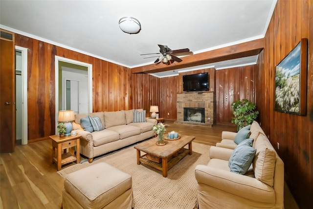 6908 Park Place Dr, Richland Hills, TX 76118 - living area with wooden walls, ceiling fan, ornamental molding, wood finished floors, and a brick fireplace