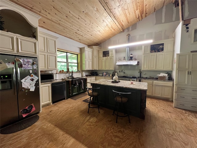 18637 Fm 17, Canton, TX 75103 - kitchen featuring stainless steel appliances, vaulted ceiling, wall chimney range hood, cream cabinets, and a breakfast bar