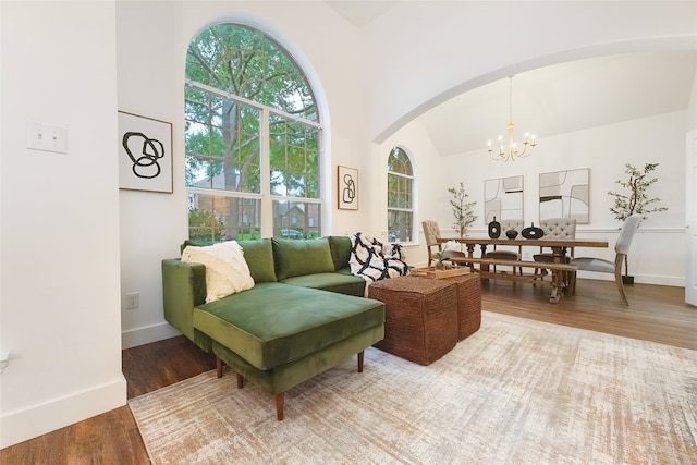 3601 Aqua Springs Dr, Plano, TX 75025 - living room with arched walkways, a chandelier, wood finished floors, baseboards, and a towering ceiling