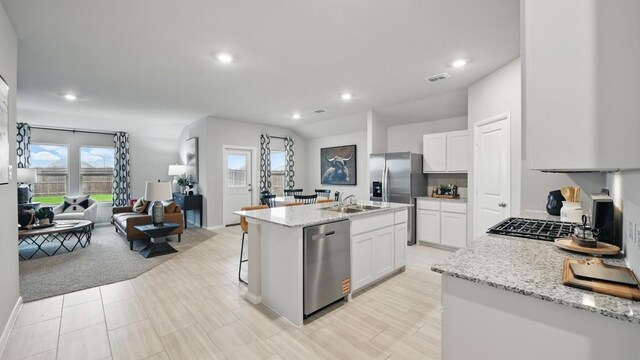 8417 Stout Dr, Fort Worth, TX 76131 - kitchen with stainless steel appliances, open floor plan, white cabinetry, an island with sink, and recessed lighting