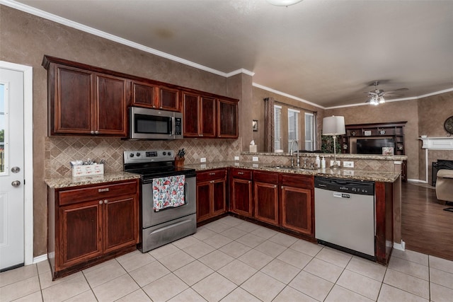 910 Glenbrook Dr, Grand Prairie, TX 75052 - kitchen featuring appliances with stainless steel finishes, a sink, open floor plan, a peninsula, and light tile patterned floors