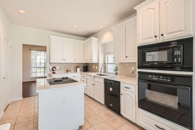 8633 Shadow Trace Dr, Fort Worth, TX 76244 - kitchen with black appliances, a sink, a center island, white cabinetry, and light tile patterned flooring