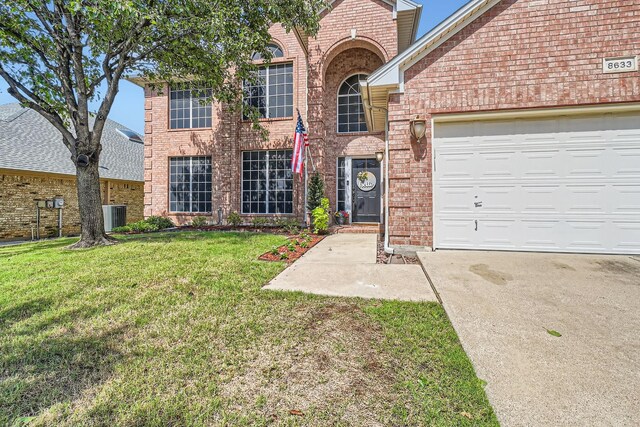 8633 Shadow Trace Dr, Fort Worth, TX 76244 - traditional home with brick siding, central AC unit, a front lawn, and driveway