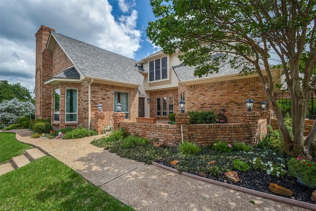4113 Southwood E, Colleyville, TX 76034 - tudor home featuring roof with shingles, a chimney, and brick siding