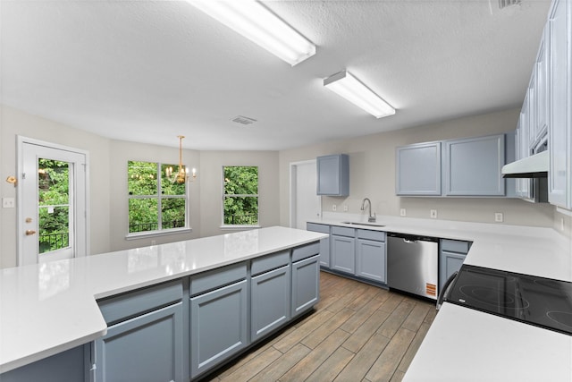1817 Cedarbriar Dr, Mesquite, TX 75181 - kitchen with dishwasher, a sink, wood finished floors, light countertops, and a textured ceiling