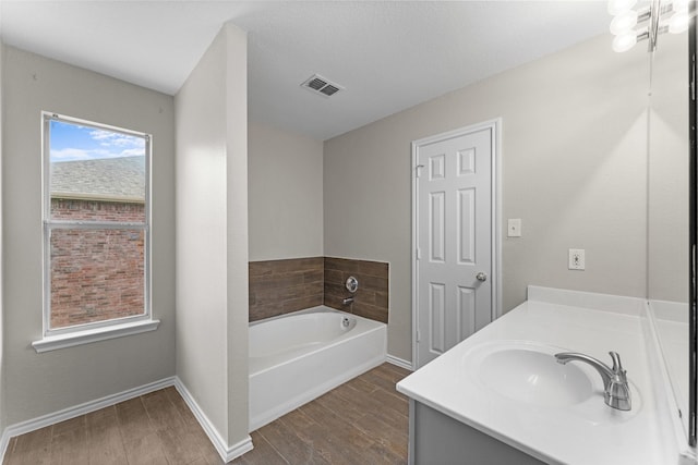 1817 Cedarbriar Dr, Mesquite, TX 75181 - bathroom featuring wood finished floors, a bath, vanity, and baseboards