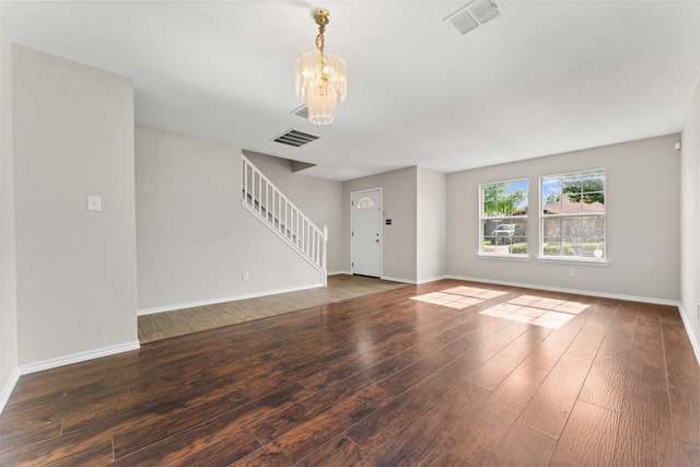 1817 Cedarbriar Dr, Mesquite, TX 75181 - unfurnished living room with stairs, a chandelier, hardwood / wood-style floors, and baseboards