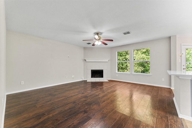 1817 Cedarbriar Dr, Mesquite, TX 75181 - unfurnished living room with a tile fireplace, a ceiling fan, dark wood-type flooring, and healthy amount of natural light
