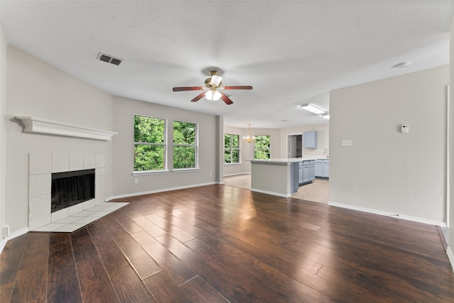 1817 Cedarbriar Dr, Mesquite, TX 75181 - unfurnished living room with ceiling fan, a fireplace, light wood-style floors, and baseboards
