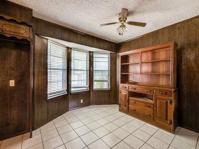 809 S Ridgeway Dr, Cleburne, TX 76033 - unfurnished office with wood walls, a textured ceiling, a ceiling fan, and light tile patterned floors