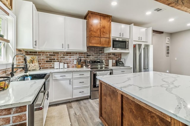 9759 Fm 638, Dawson, TX 76639 - kitchen featuring appliances with stainless steel finishes, light wood-style flooring, backsplash, white cabinets, and recessed lighting
