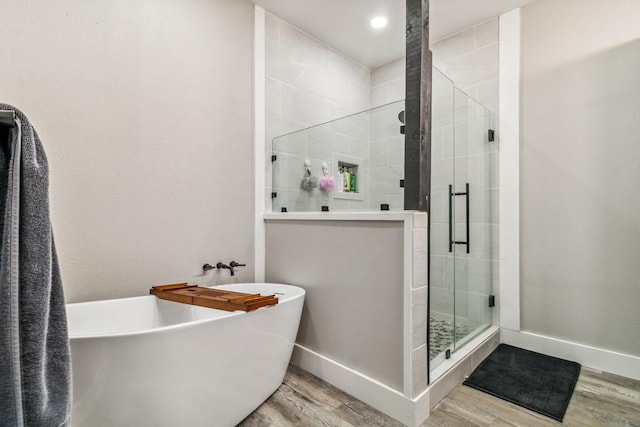 9759 Fm 638, Dawson, TX 76639 - bathroom with wood finished floors, a freestanding bath, a stall shower, baseboards, and recessed lighting