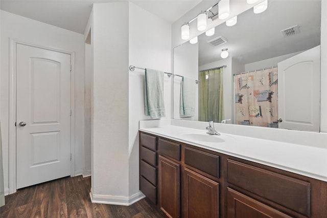 1445 Macy Ln, Dallas, TX 75253 - bathroom featuring baseboards, wood finished floors, vanity, and curtained shower