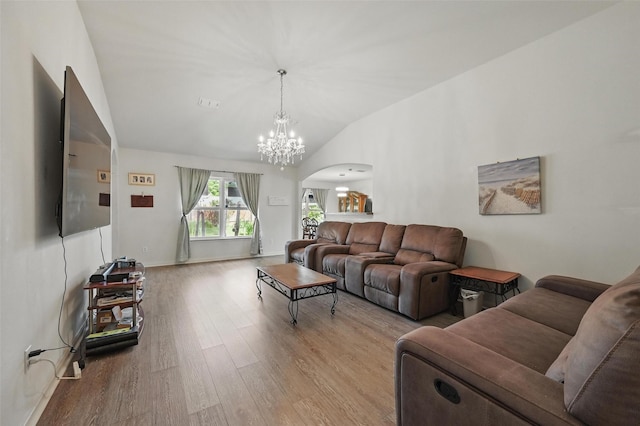 1445 Macy Ln, Dallas, TX 75253 - living room with arched walkways, wood finished floors, lofted ceiling, and a chandelier
