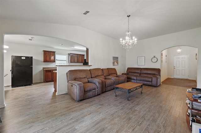 1445 Macy Ln, Dallas, TX 75253 - living area with arched walkways, light wood finished floors, a chandelier, and vaulted ceiling