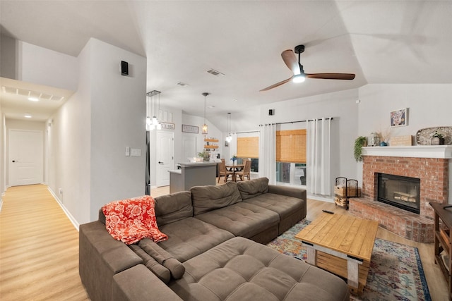 1711 Sage Dr, Midlothian, TX 76065 - living area featuring light wood-style floors, a brick fireplace, a ceiling fan, lofted ceiling, and baseboards