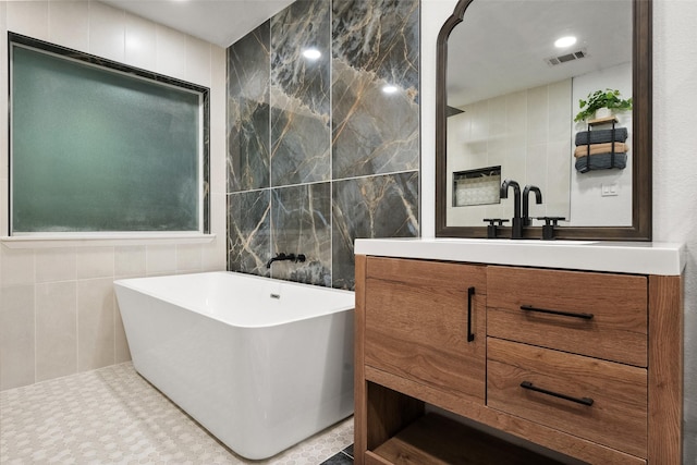 1711 Sage Dr, Midlothian, TX 76065 - bathroom with walk in shower, tile walls, tile patterned floors, vanity, and a freestanding bath