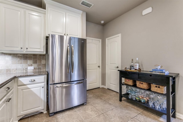 544 S Greenville Ave, Richardson, TX 75081 - kitchen featuring freestanding refrigerator, white cabinets, light tile patterned floors, and light stone counters