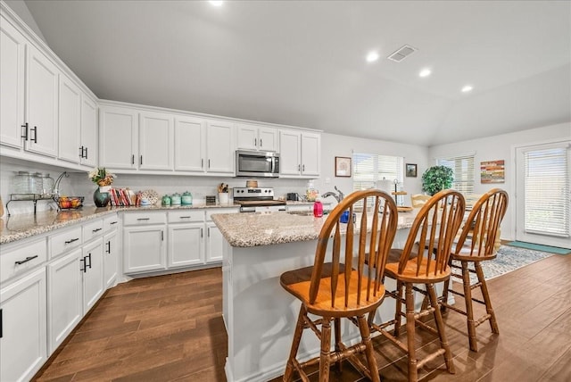 609 Autumn Ave, Justin, TX 76247 - kitchen with appliances with stainless steel finishes, dark wood finished floors, healthy amount of natural light, lofted ceiling, and white cabinetry