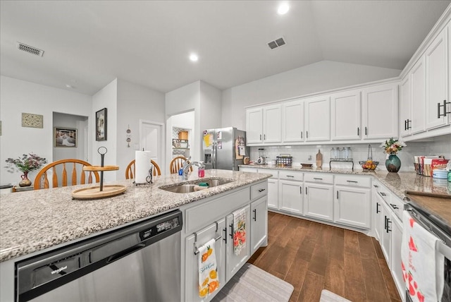 609 Autumn Ave, Justin, TX 76247 - kitchen with stainless steel appliances, a sink, dark wood finished floors, white cabinetry, and backsplash