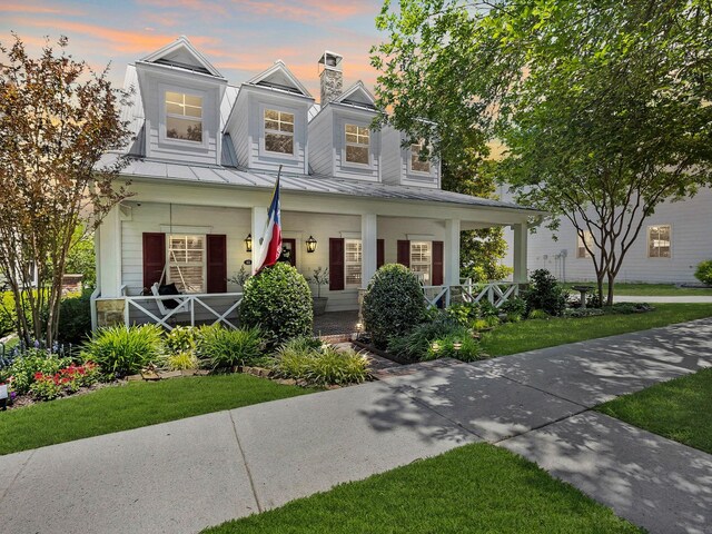 411 Jordan Farm Cir, Rockwall, TX 75087 - view of front of home with covered porch, a standing seam roof, metal roof, a chimney, and a front yard