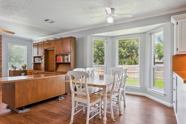 108 Neely Rd, Hewitt, TX 76643 - dining space featuring ceiling fan, dark wood finished floors, plenty of natural light, a textured ceiling, and ornamental molding