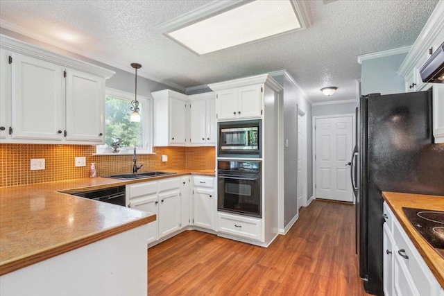 108 Neely Rd, Hewitt, TX 76643 - kitchen featuring oven, stainless steel microwave, wood finished floors, a sink, and white cabinets
