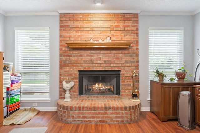 108 Neely Rd, Hewitt, TX 76643 - detailed view of wood finished floors, a brick fireplace, baseboards, and crown molding