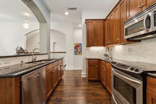 2022 N Fitzhugh Ave Unit E, Dallas, TX 75204 - kitchen with stainless steel appliances, a sink, decorative backsplash, arched walkways, and dark wood-style flooring