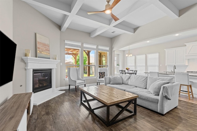945 Colby Bluff Dr, Rockwall, TX 75087 - living area featuring coffered ceiling, a glass covered fireplace, beam ceiling, dark wood-type flooring, and ceiling fan