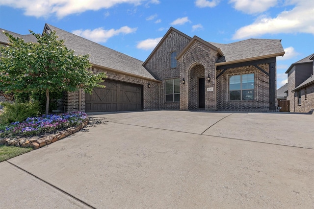 945 Colby Bluff Dr, Rockwall, TX 75087 - french country inspired facade featuring brick siding, a garage, concrete driveway, and roof with shingles