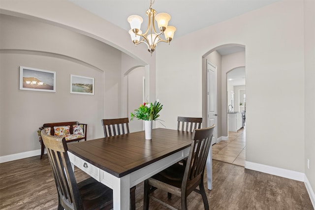 945 Colby Bluff Dr, Rockwall, TX 75087 - dining room featuring arched walkways, wood finished floors, baseboards, and a chandelier