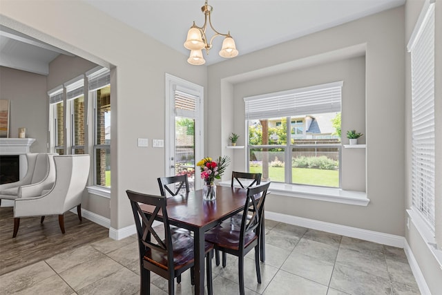 945 Colby Bluff Dr, Rockwall, TX 75087 - dining area with a chandelier, baseboards, light tile patterned flooring, and a fireplace