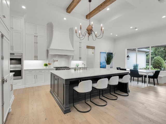 2161 Honey Ln, Celina, TX 75009 - kitchen featuring custom range hood, double oven, light wood-type flooring, a chandelier, and white cabinets
