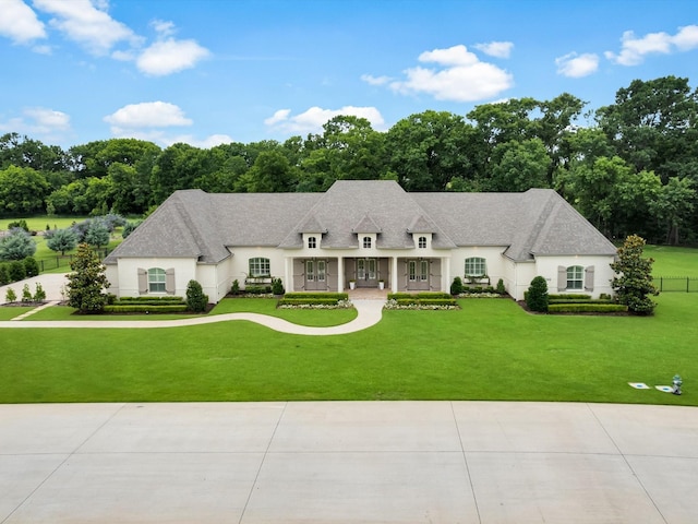 2161 Honey Ln, Celina, TX 75009 - french country home with stucco siding, a front lawn, a shingled roof, and view of scattered trees