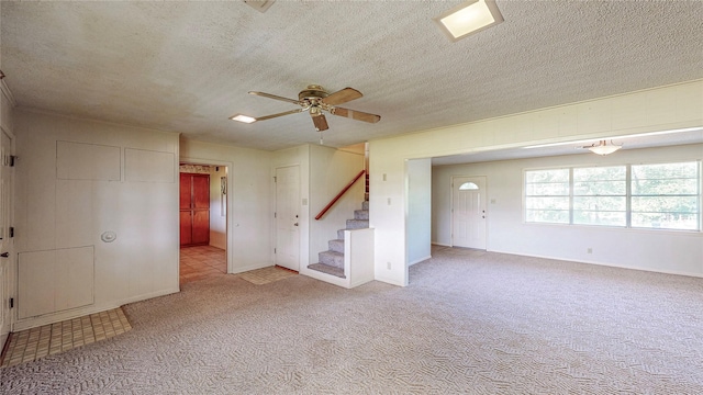 10335 Nolan Dr, Tyler, TX 75709 - spare room featuring a ceiling fan, stairway, a textured ceiling, baseboards, and carpet flooring