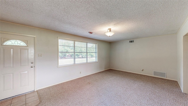 10335 Nolan Dr, Tyler, TX 75709 - foyer featuring healthy amount of natural light, carpet, a textured ceiling, and baseboards