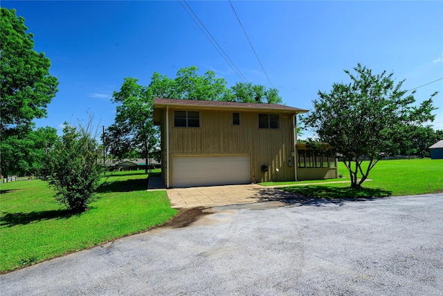 10335 Nolan Dr, Tyler, TX 75709 - view of front of house featuring driveway, an attached garage, and a front lawn