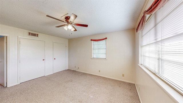 10335 Nolan Dr, Tyler, TX 75709 - unfurnished bedroom with a textured ceiling, light carpet, a ceiling fan, and baseboards